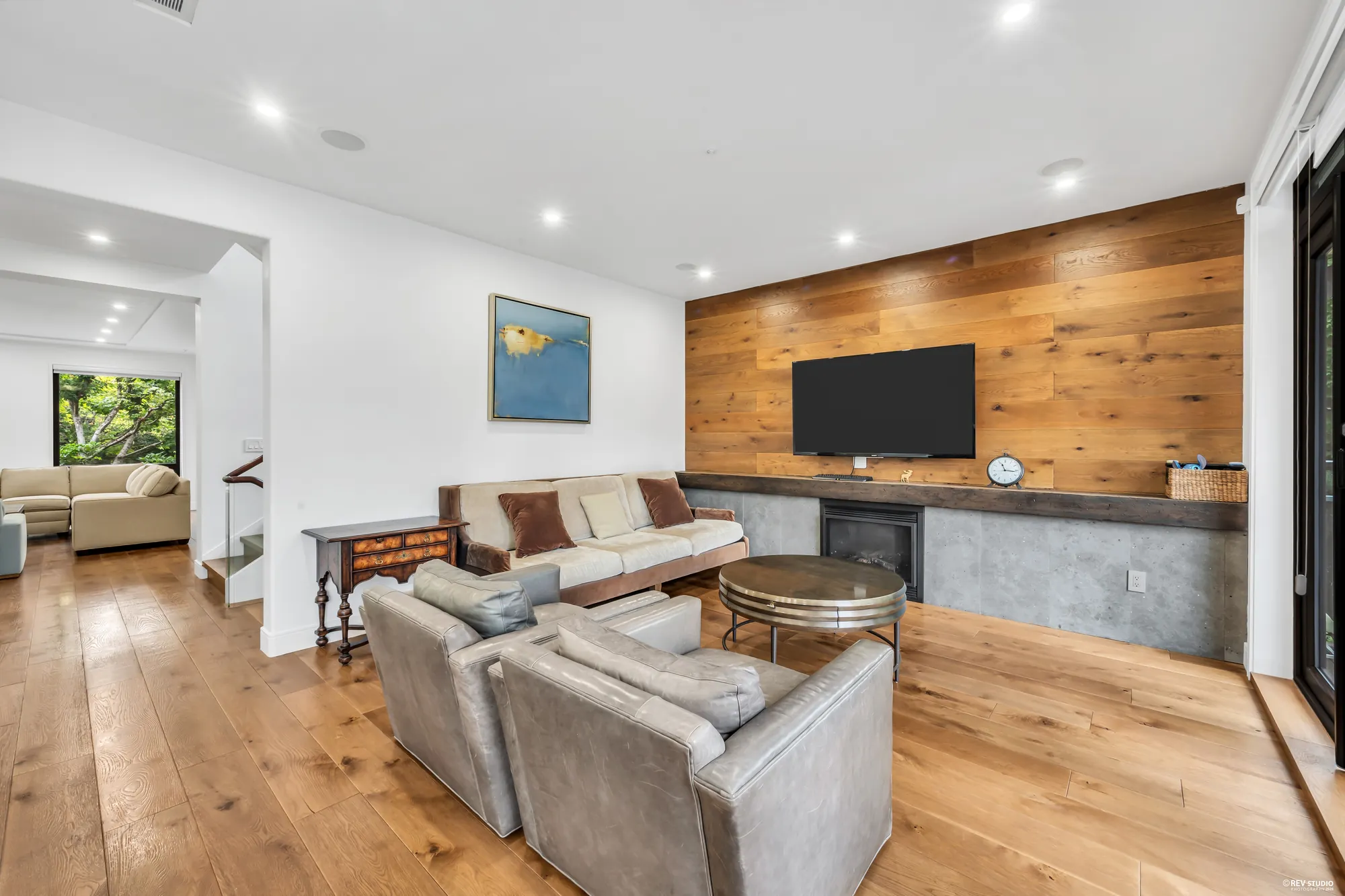The family room from the kitchen side, the sofas and the wood wall