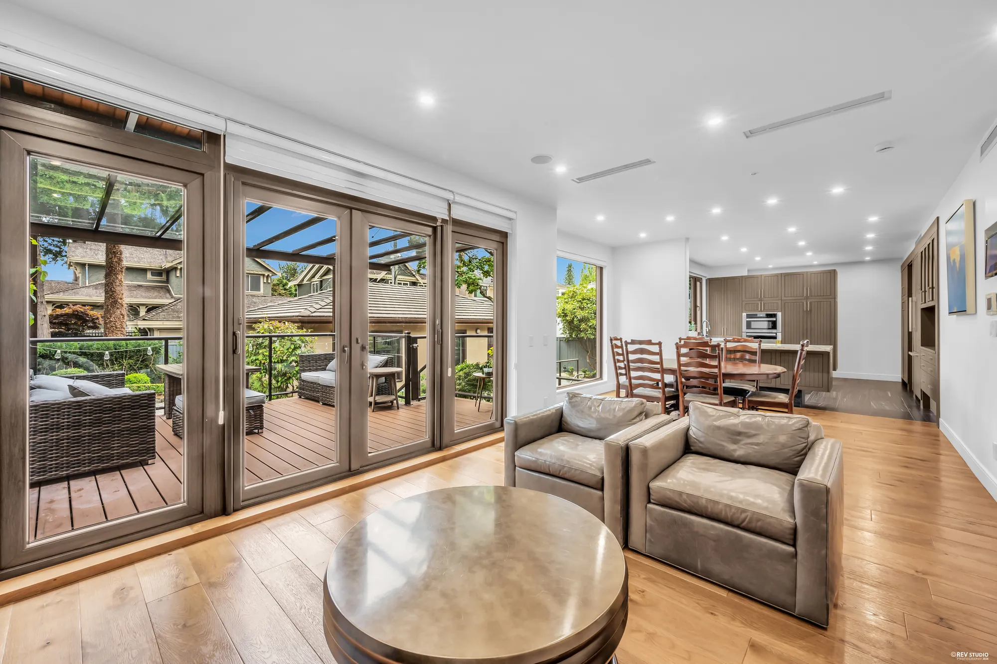 The family room with its glass doors, the deck and the pergola beyond