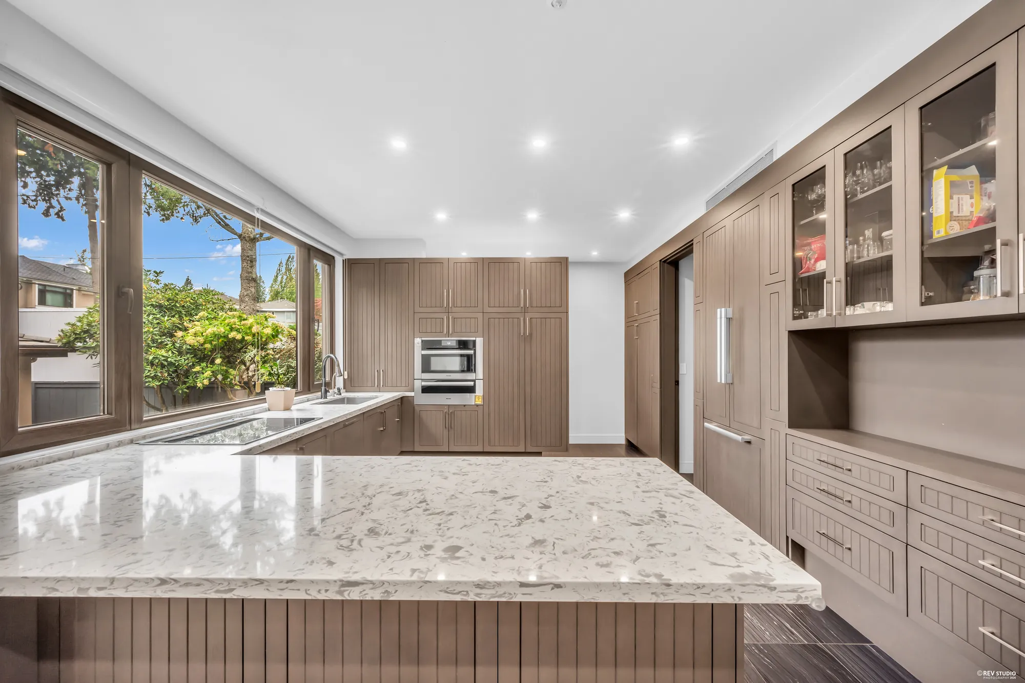 The kitchen along the counter, the tall cabinets and the ovens
