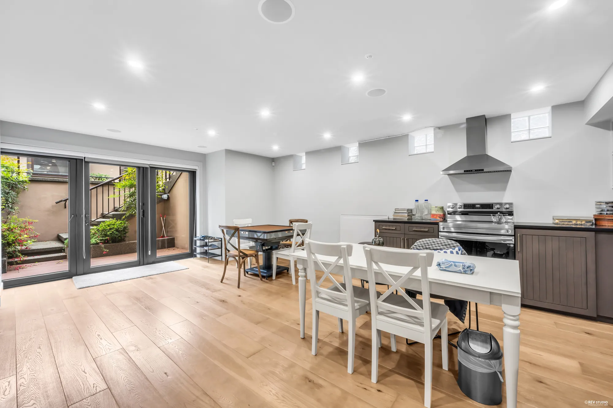 The lower kitchen: a table and chairs, the range under its hood, and the door to the patio stair on the left