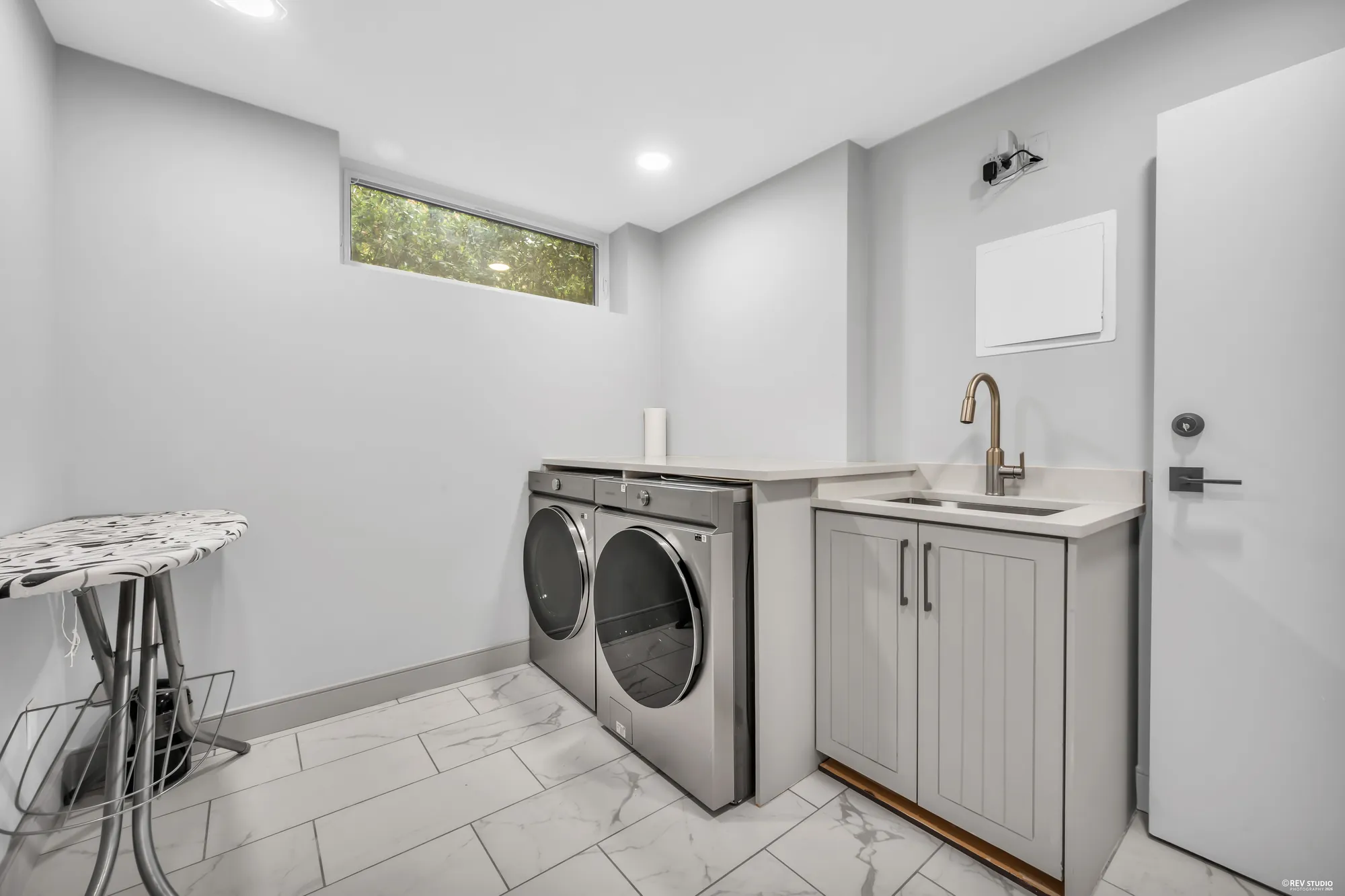 A laundry with a sink cabinet, a washer and a dryer
