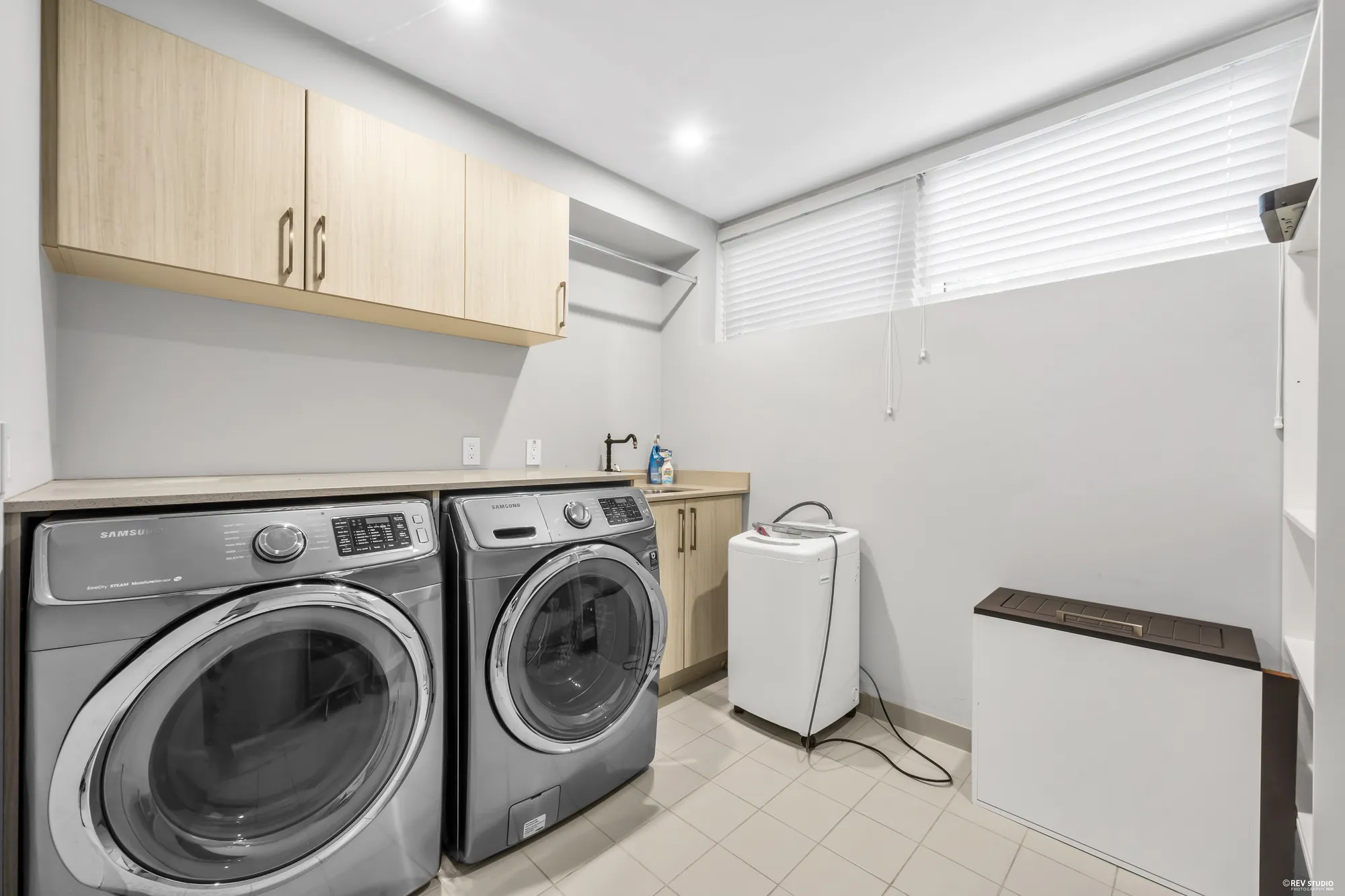 The second laundry: cabinets over the washer and dryer, a utility sink