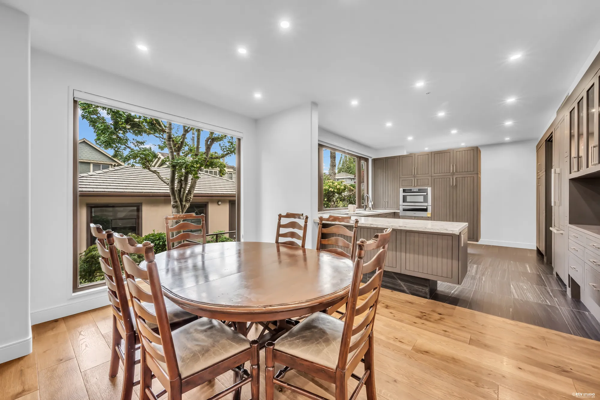 The breakfast nook: a round table and chairs in the window, the kitchen beyond