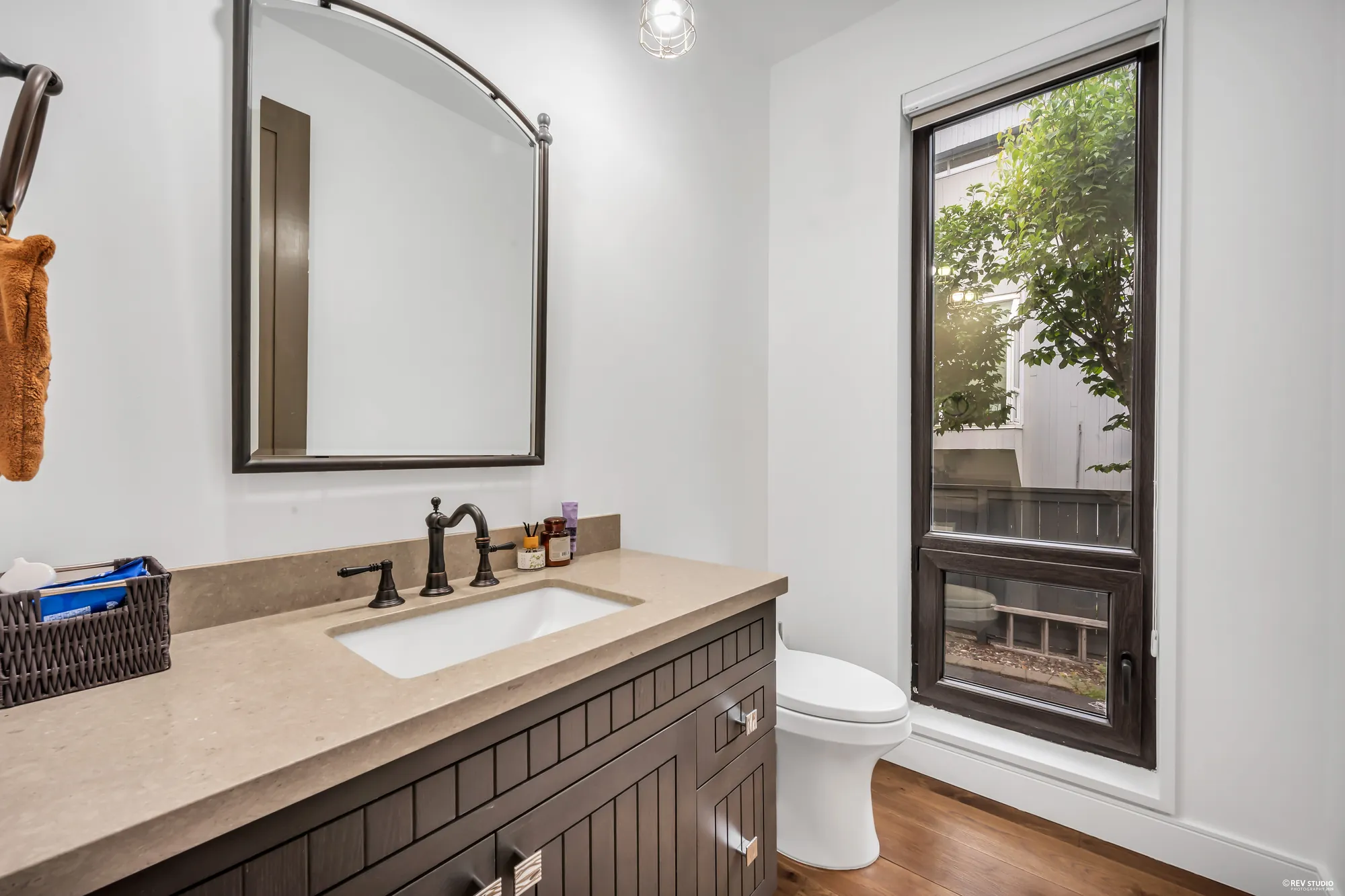 The powder room: a vanity with a stone top and a framed mirror, a window